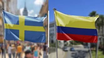 Banderas de Suecia y Colombia ondeando juntas en un entorno urbano.