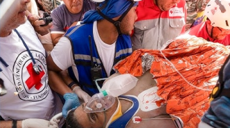 Equipos de la Cruz Roja brindan primeros auxilios a Hernán Gil tras ser rescatado con vida después de ocho días bajo los escombros en La Guaira, Venezuela.