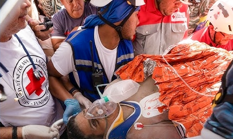 Equipos de la Cruz Roja brindan primeros auxilios a Hernán Gil tras ser rescatado con vida después de ocho días bajo los escombros en La Guaira, Venezuela.