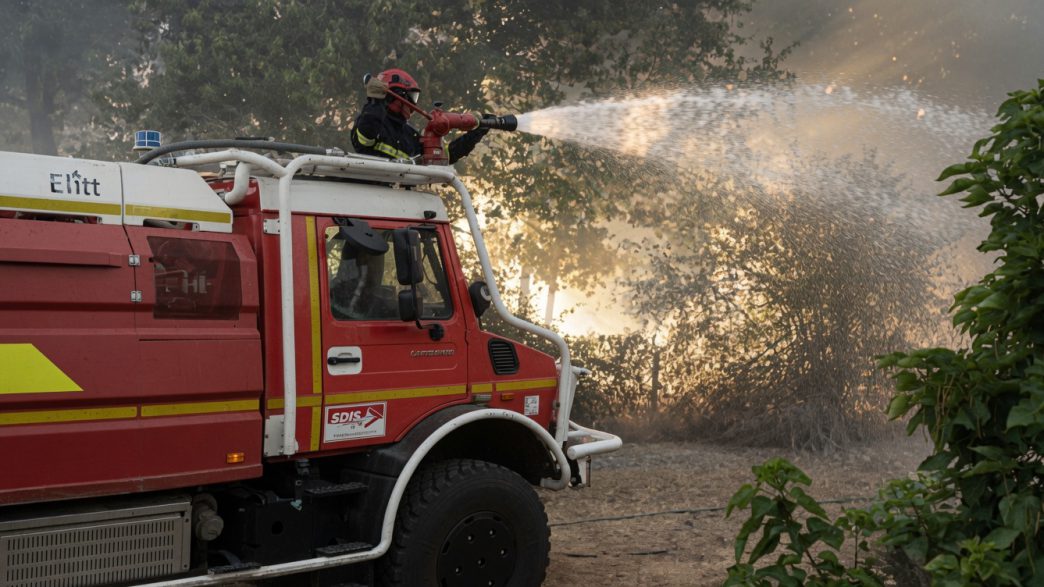 Camión de bomberos combatiendo un incendio forestal en territorio francés durante la ola de fuegos.