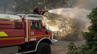 Camión de bomberos combatiendo un incendio forestal en territorio francés durante la ola de fuegos.