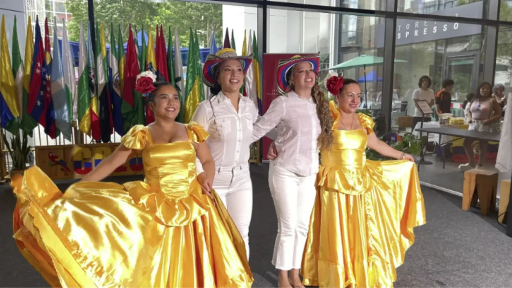 Bailarinas con trajes típicos amarillos y blancos celebrando el Día de la Independencia de Colombia en Hammersmith, Londres.