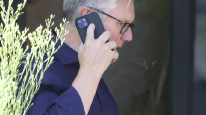 Sir Keir Starmer sosteniendo una pinta de cerveza y hablando por teléfono tras su dimisión.