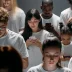 Personas de diversas edades utilizando sus teléfonos móviles en un espacio público.