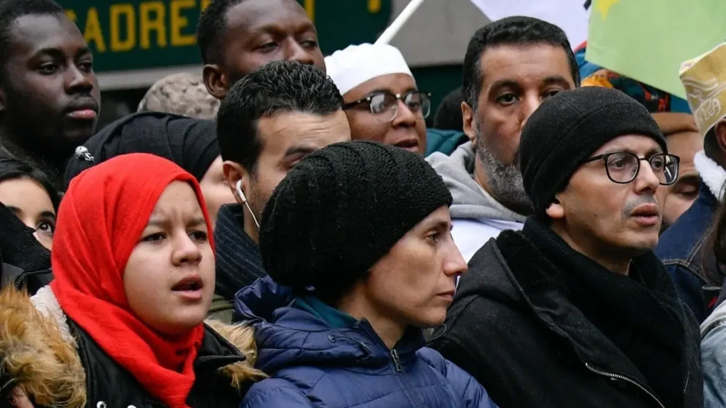 Grupo de personas migrantes y ciudadanos participando en una manifestación en Francia.