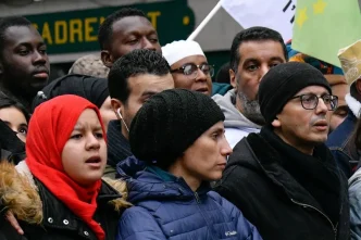 Grupo de personas migrantes y ciudadanos participando en una manifestación en Francia.
