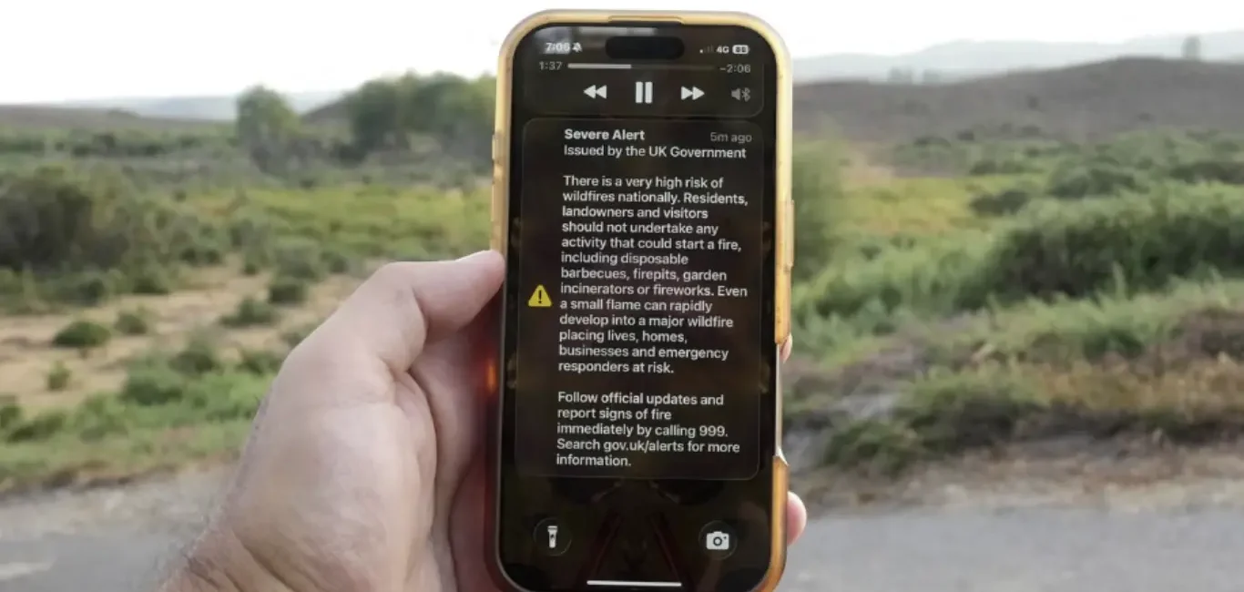 Pantalla de un teléfono móvil que muestra una alerta de emergencia del Gobierno del Reino Unido sobre incendios forestales