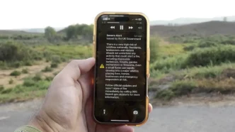 Pantalla de un teléfono móvil que muestra una alerta de emergencia del Gobierno del Reino Unido sobre incendios forestales