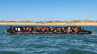 Lancha neumática gigante sobrecargada con decenas de migrantes navegando cerca de la costa