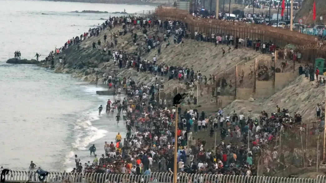 Acumulación de personas en la zona fronteriza y costera de Ceuta durante la crisis migratoria.