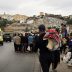 Grupo de migrantes y una ambulancia en una carretera tras la llegada masiva a Ceuta