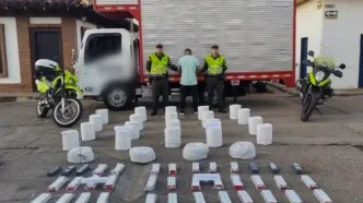 Autoridades policiales junto a un camión intervenido y material explosivo incautado en un operativo en Colombia.