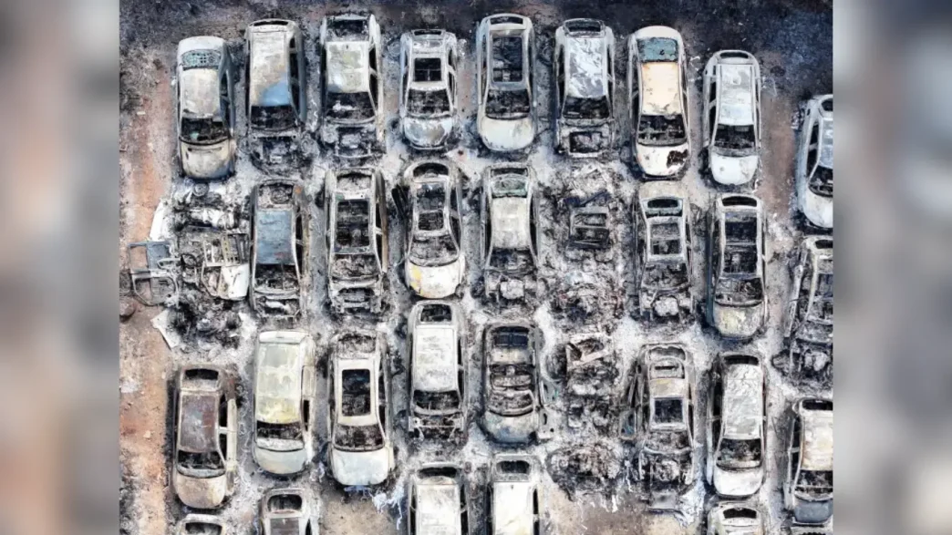 Vista aérea de decenas de coches quemados y completamente destruidos tras el devastador incendio en el aparcamiento