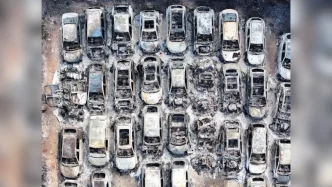Vista aérea de decenas de coches quemados y completamente destruidos tras el devastador incendio en el aparcamiento