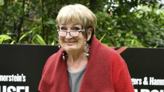 Retrato sonriente de la locutora y periodista británica Dame Jenni Murray con gafas y abrigo rojo