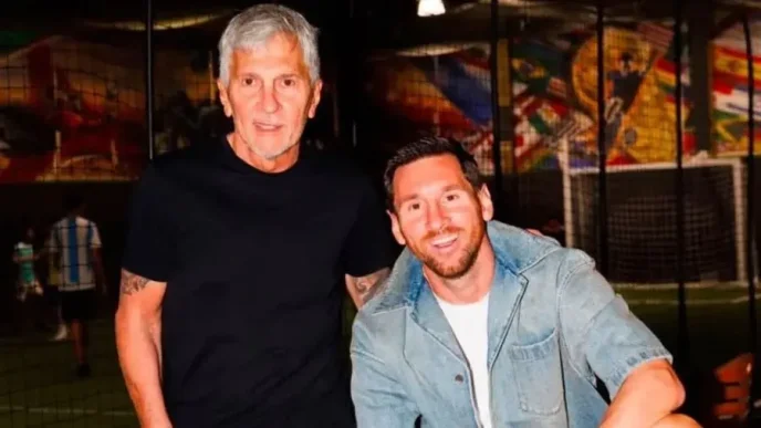 Lionel Messi junto a su padre y representante Jorge Messi sonriendo en un espacio deportivo