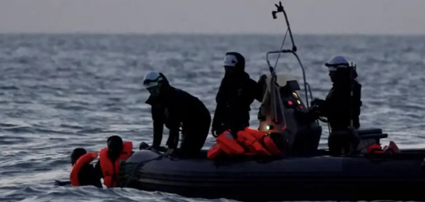 Equipos de rescate y seguridad operando en una pequeña embarcación con migrantes en alta mar.