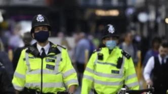 Agentes de policía británica patrullando en la vía pública.