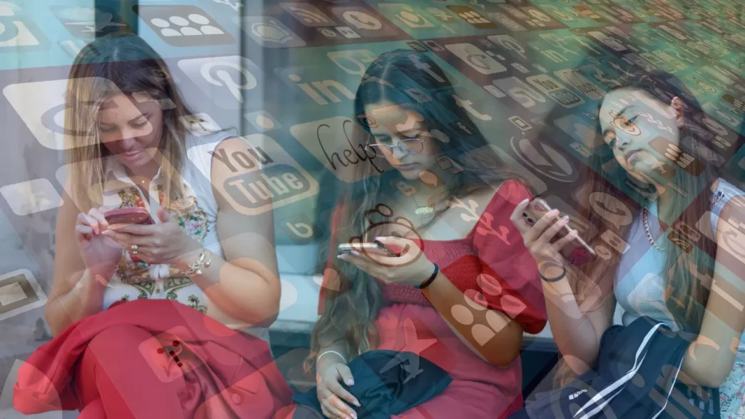 Jóvenes utilizando sus teléfonos móviles rodeadas por un gráfico de iconos de redes sociales