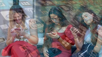 Jóvenes utilizando sus teléfonos móviles rodeadas por un gráfico de iconos de redes sociales