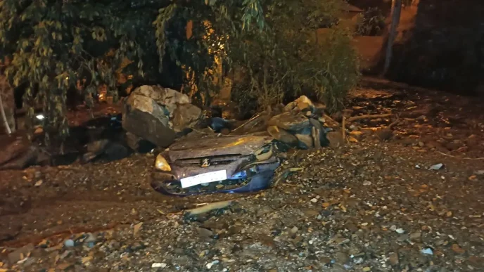 Coche sepultado por rocas, lodo y ramas tras la riada en Manzanedo de Valdueza