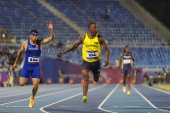 El velocista colombiano Ronal Longa corriendo con la camiseta número 184 en la pista de atletismo.