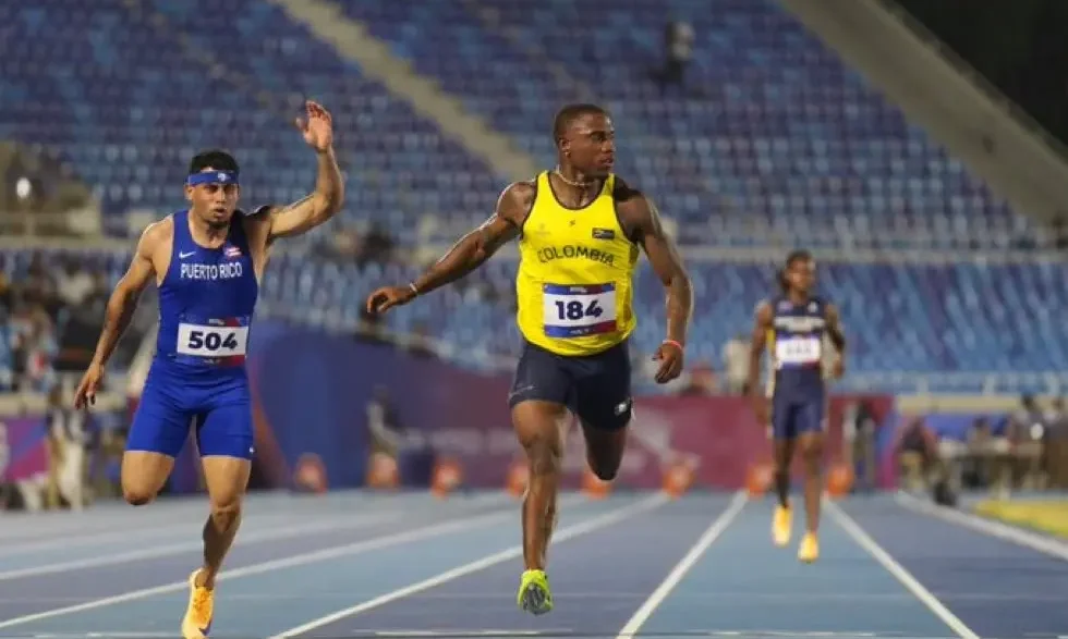 El velocista colombiano Ronal Longa corriendo con la camiseta número 184 en la pista de atletismo.