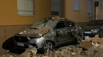 Vehículo dañado por la caída de escombros y ladrillos tras el terremoto en Granada