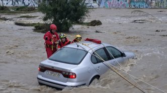 Equipos de rescate trabajando en la evacuación de un coche atrapado por inundaciones causadas por fuertes lluvias