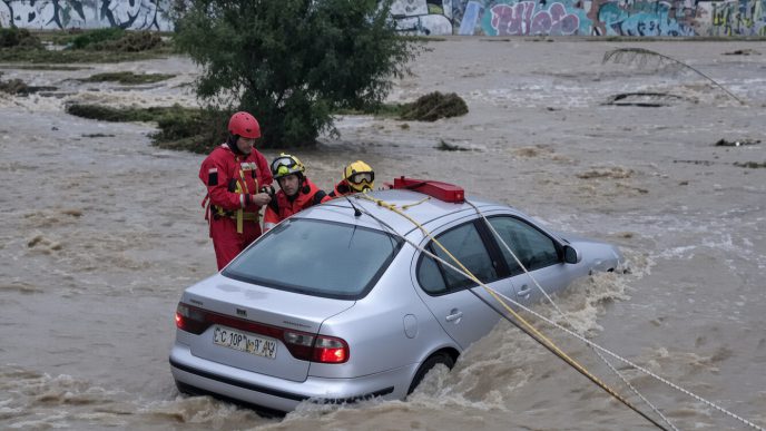 Equipos de rescate trabajando en la evacuación de un coche atrapado por inundaciones causadas por fuertes lluvias