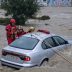 Equipos de rescate trabajando en la evacuación de un coche atrapado por inundaciones causadas por fuertes lluvias