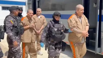 Reclusos rapados y uniformados esposados en parejas durante un operativo de traslado carcelario