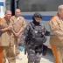 Reclusos rapados y uniformados esposados en parejas durante un operativo de traslado carcelario