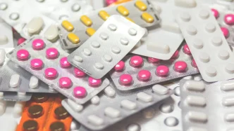 Blísteres de medicamentos y pastillas de diferentes colores sobre una superficie