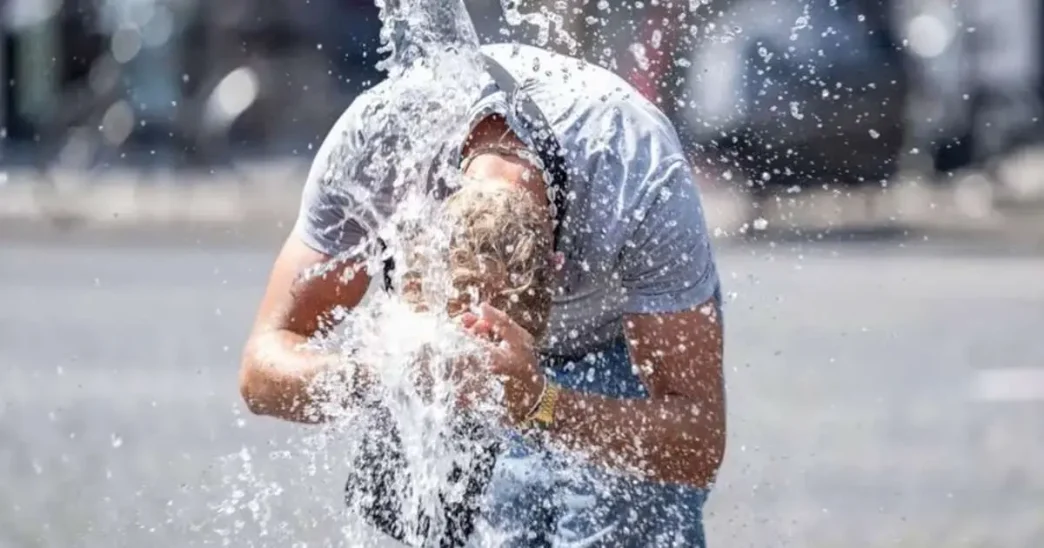 Persona refrescándose con agua en medio de una intensa ola de calor en Europa