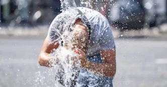 Persona refrescándose con agua en medio de una intensa ola de calor en Europa