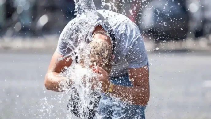 Persona refrescándose con agua en medio de una intensa ola de calor en Europa