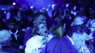 Una activista ecologista es desalojada violentamente entre la multitud durante la conferencia de Reform UK.