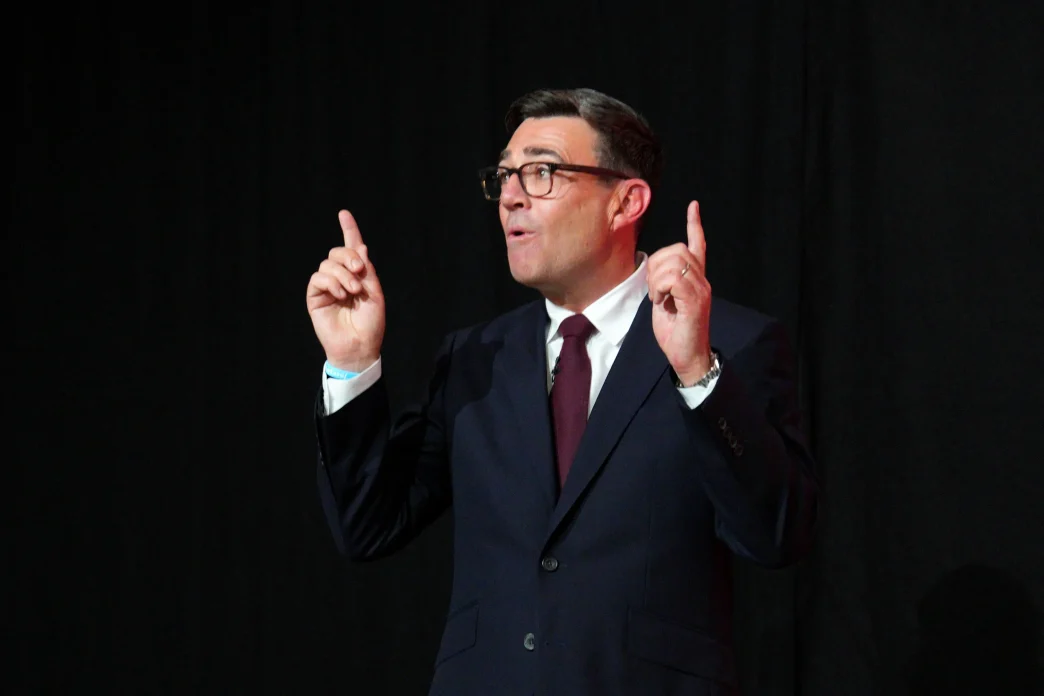El primer ministro británico Andy Burnham gesticulando con las manos durante una intervención pública