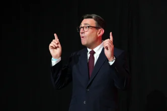 El primer ministro británico Andy Burnham gesticulando con las manos durante una intervención pública