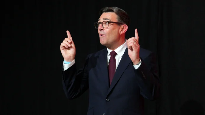 El primer ministro británico Andy Burnham gesticulando con las manos durante una intervención pública