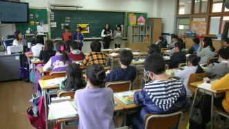 Estudiantes de diversas nacionalidades sentados en un aula de clase en Italia durante una lección.