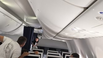 Pasajeros dentro de la cabina de un avión en un momento de tensión e incertidumbre durante el vuelo.