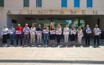 Concentración silenciosa de la corporación municipal frente a las puertas del Ayuntamiento de Benidorm sosteniendo pancartas con el lema "Benidorm dice ¡NO! a la violencia de género".