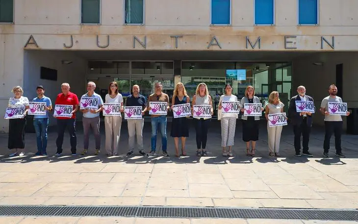 Concentración silenciosa de la corporación municipal frente a las puertas del Ayuntamiento de Benidorm sosteniendo pancartas con el lema "Benidorm dice ¡NO! a la violencia de género".