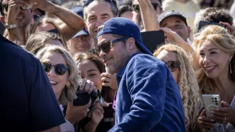 Brad Pitt saluda a una multitud de seguidores fotografiándole a su llegada al Festival de San Sebastián.