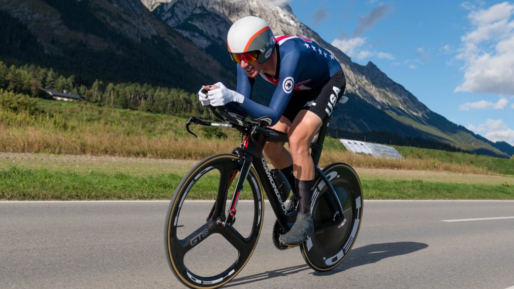 Ciclista Brandon McNulty acoplado en su bicicleta de contrarreloj vistiendo el uniforme de la selección de Estados Unidos.