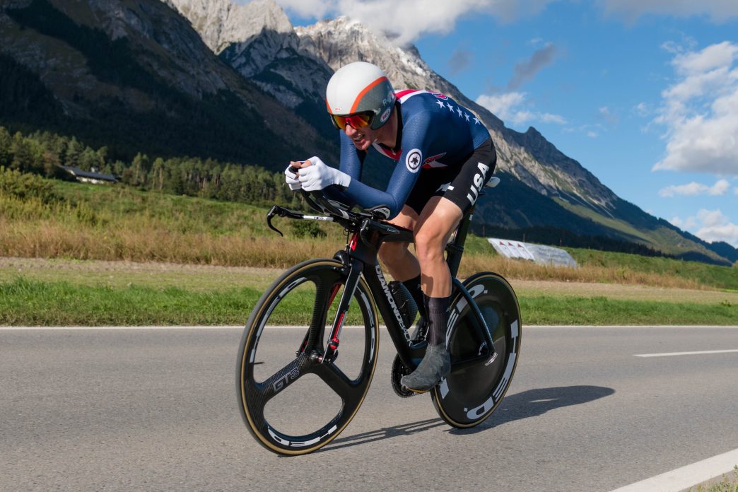 Ciclista Brandon McNulty acoplado en su bicicleta de contrarreloj vistiendo el uniforme de la selección de Estados Unidos.