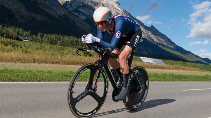 Ciclista Brandon McNulty acoplado en su bicicleta de contrarreloj vistiendo el uniforme de la selección de Estados Unidos.