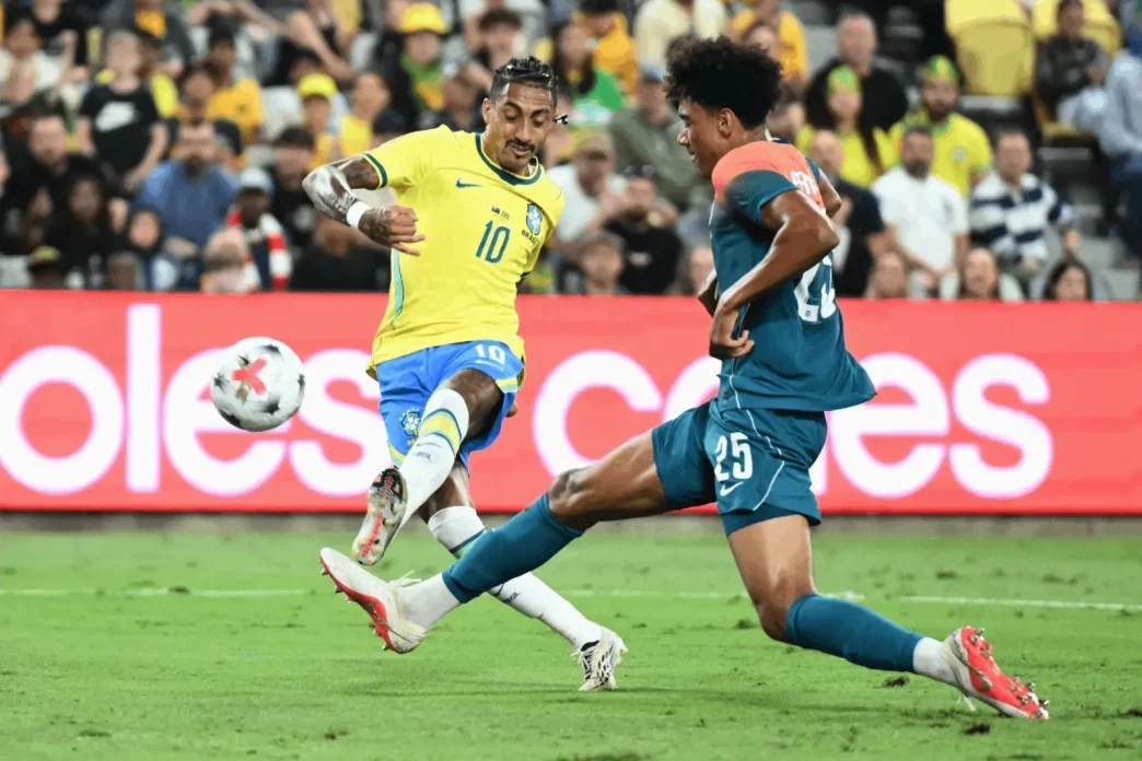 Raphinha controlando el balón con el dorsal 10 de la selección de Brasil frente a un defensor de Australia.